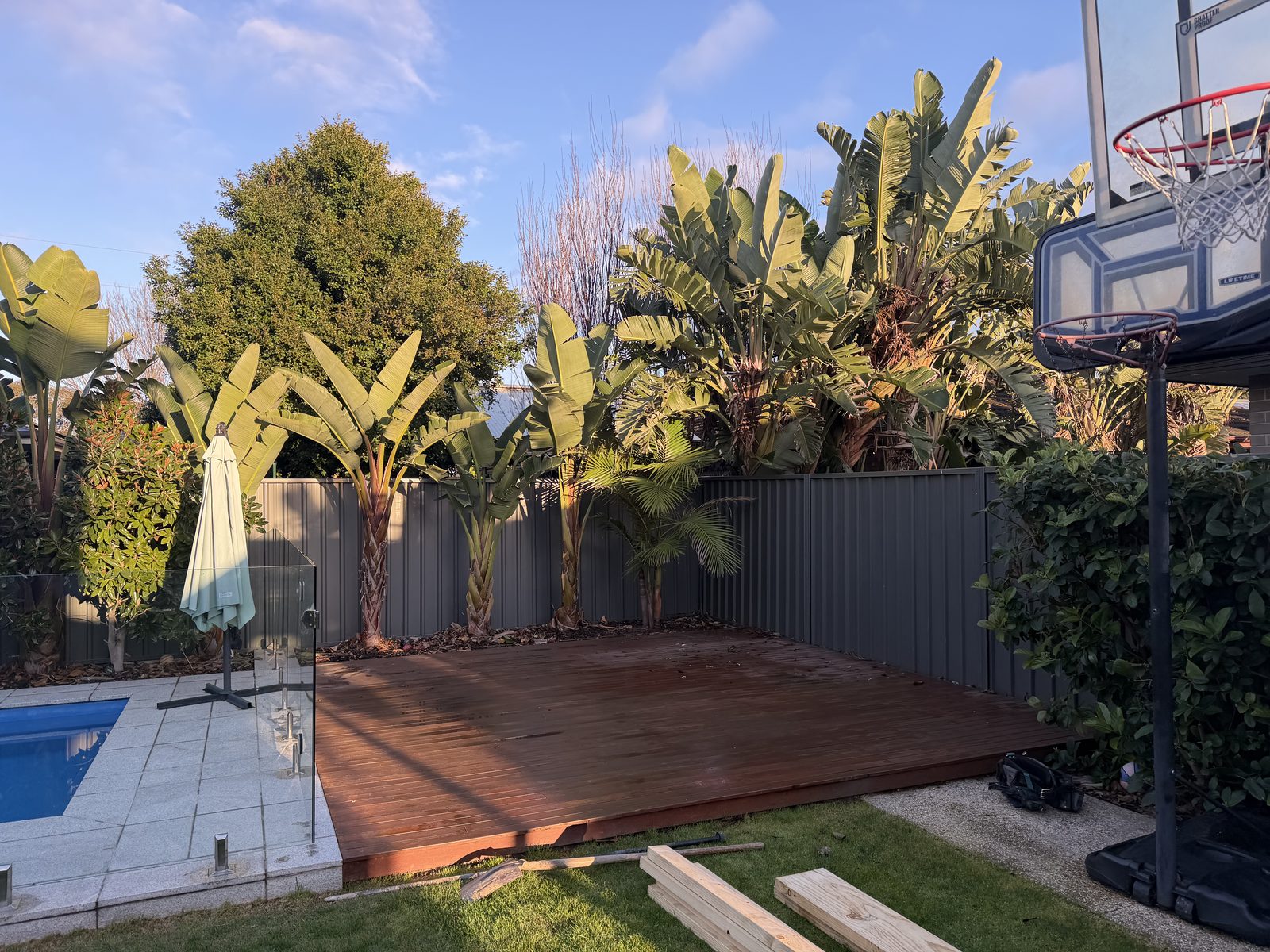 Before: bare timber deck beside the pool, no shade